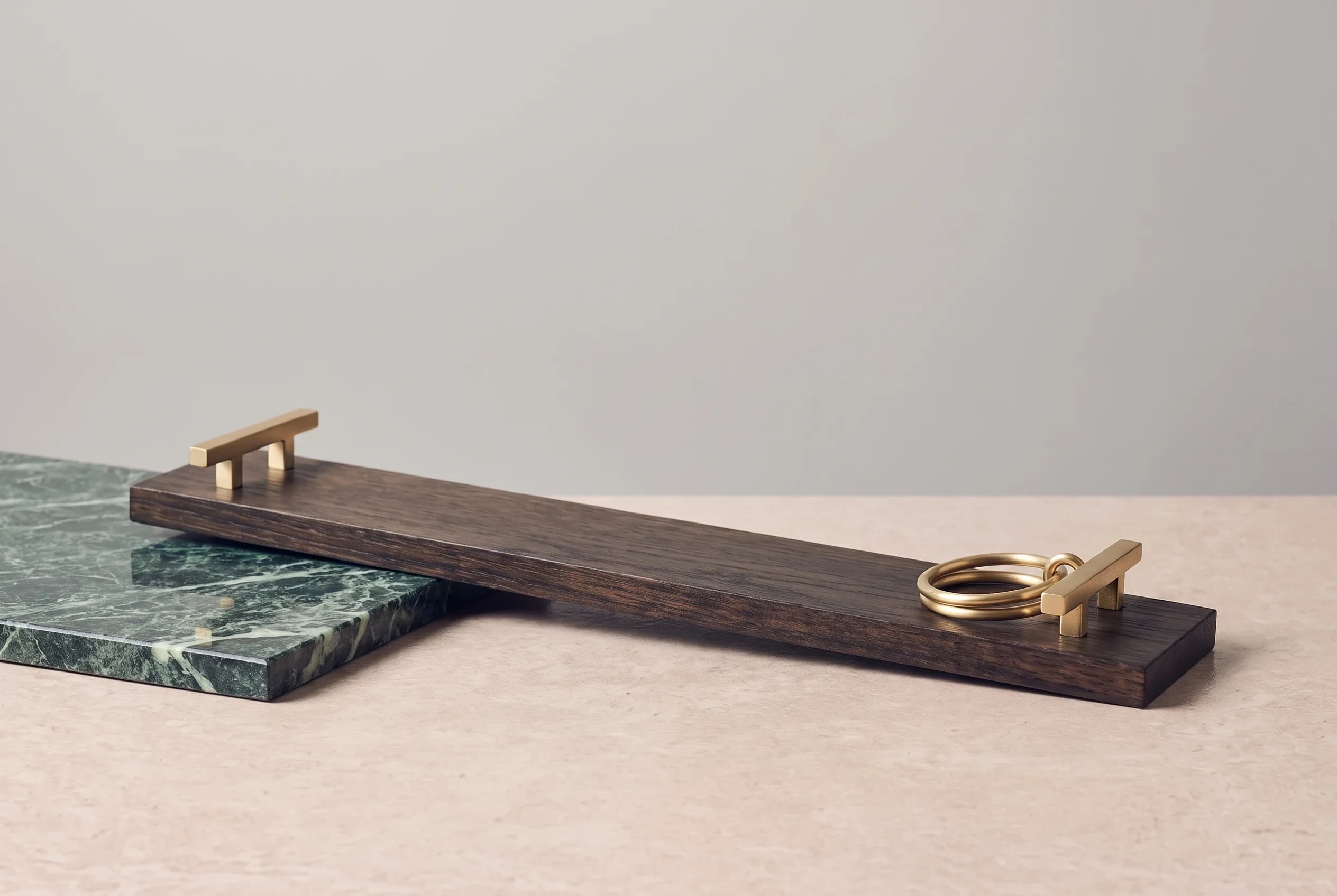 Still life of a dark oak jetty plank with brushed brass cleats on a travertine surface against a grey wall, in the fixed Atljet cover style.